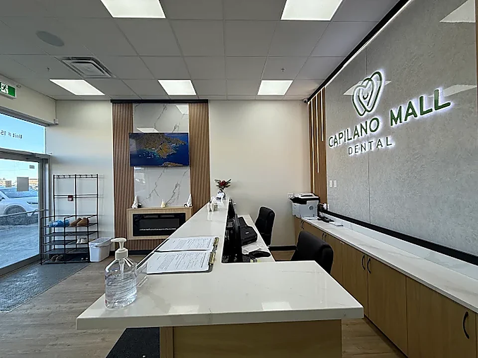 Front desk at Capilano Mall Dental with quartz counters and the backlit clinic sign