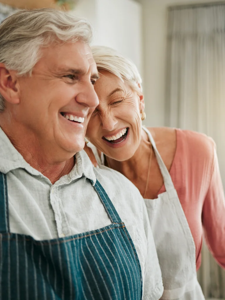 Older couple laughing together at home