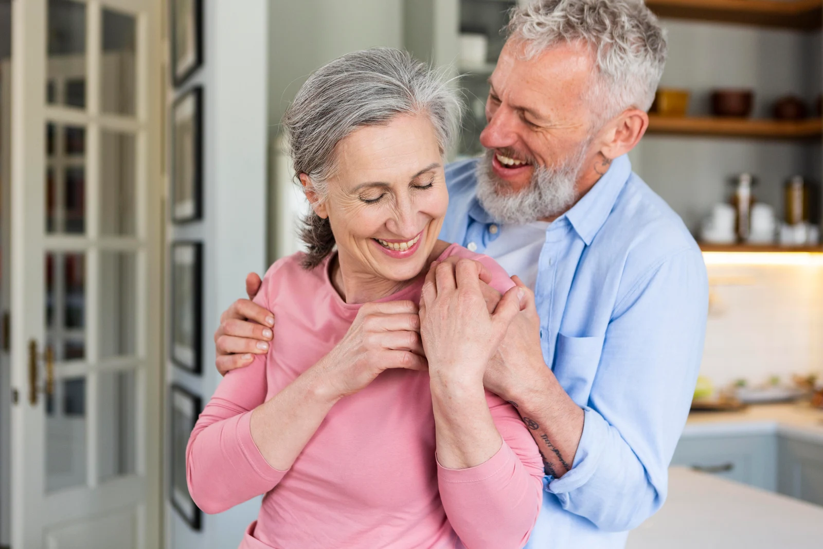 Older couple smiling together in their kitchen